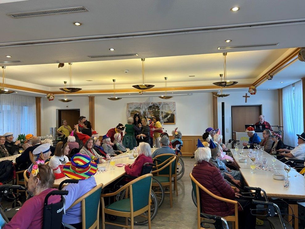 Bild von Speisesaal mit verkleideten Bewohner*innen