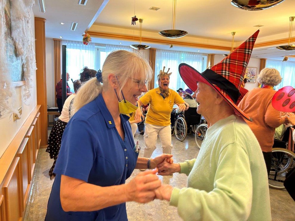 Verkleidete Mitarbeiterin und verkleidete Bewohnerin mit rotem Hut