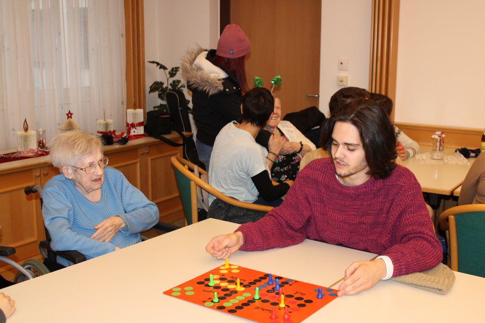 Jugendlicher spielt mit Bewohnerin