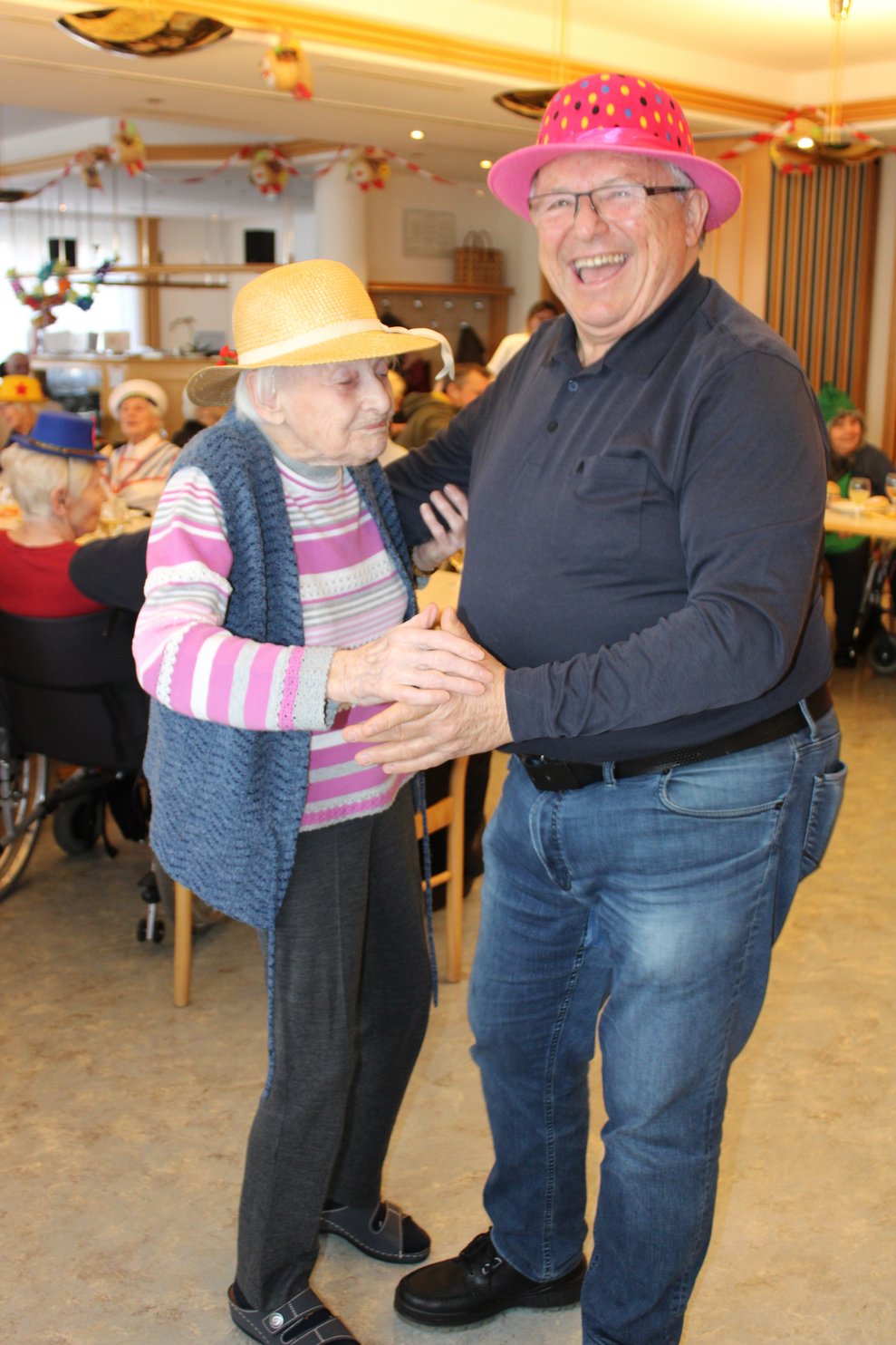 Bewohnerin tanzt mit Ehrenamtlichen